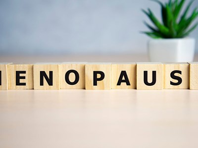 Letter blocks spelling out the word menopause on a table.