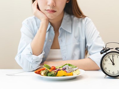 Fork and knife near plate with white clock